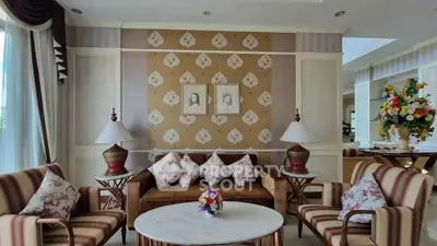 Elegant living room with classic decor, plush seating, and stylish wallpaper, perfect for sophisticated gatherings.