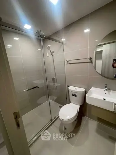 Modern bathroom with glass shower enclosure and sleek fixtures