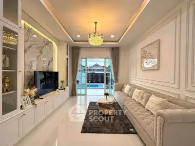 Luxurious living room with elegant decor and large windows opening to a balcony.