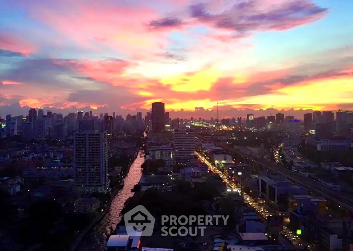Stunning cityscape view at sunset with vibrant sky over urban skyline, perfect for high-rise living.