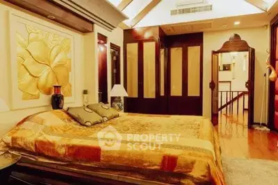 Luxurious bedroom with elegant decor and warm lighting, featuring a plush bed and stylish furnishings.