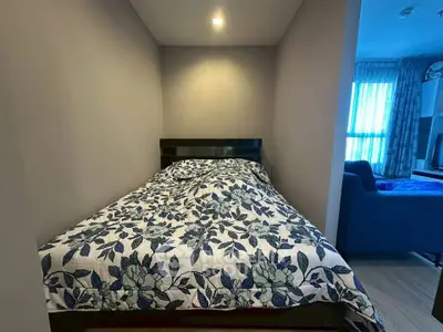 Cozy bedroom with floral bedding and adjacent living area in modern apartment