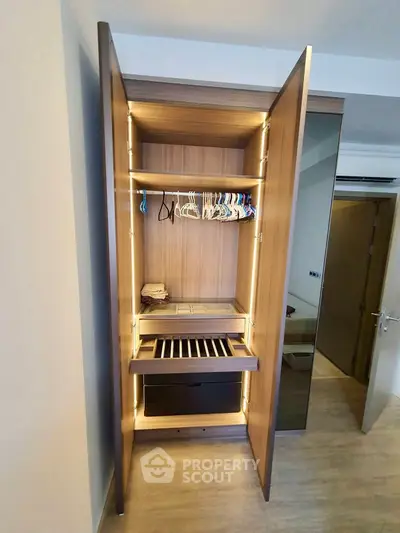 Modern wardrobe with open doors showcasing ample storage space and sleek design in a contemporary bedroom.