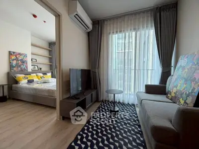 Modern living room with stylish decor and natural light, adjacent to cozy bedroom.