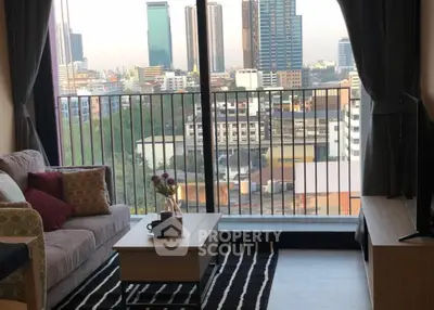 Stylish living room with city view from balcony, modern decor and cozy seating.