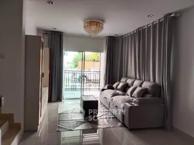 Spacious living room with elegant chandelier and modern gray sofa, perfect for relaxation and entertainment.