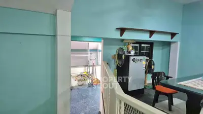 Charming interior with vibrant teal walls and modern appliances, perfect for cozy living.