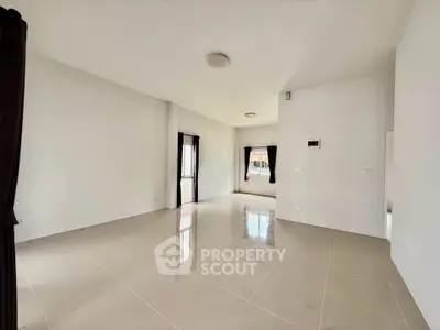 Spacious empty living room with large windows and glossy tiled floor