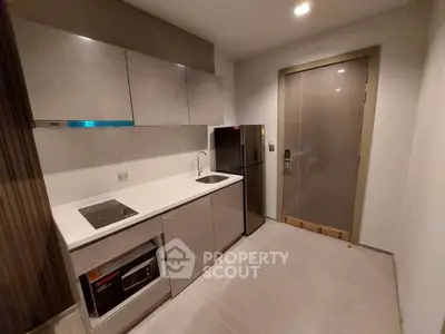 Modern kitchen with sleek cabinetry and built-in appliances in a compact layout.
