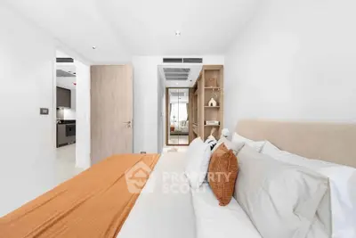 Modern bedroom with stylish decor and neutral tones, featuring a cozy bed and elegant furnishings.