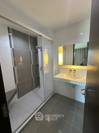 Modern bathroom with sleek shower and stylish sink in contemporary apartment.