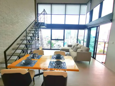 Stunning loft apartment with floor-to-ceiling windows and city view, featuring modern dining and living area.