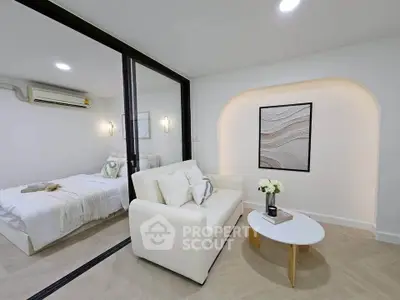 Modern living room with cozy sofa and stylish decor adjacent to a serene bedroom.