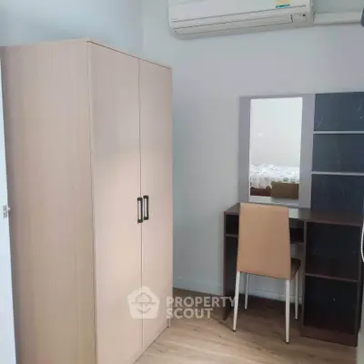 Cozy bedroom corner with wardrobe, desk, and air conditioning in modern apartment.