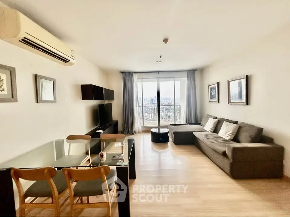 Spacious living room with modern furniture and city view, perfect for urban living.
