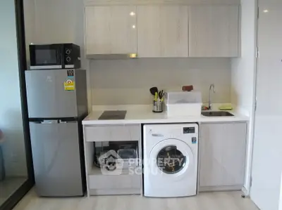 Modern kitchen with washing machine and fridge in compact layout