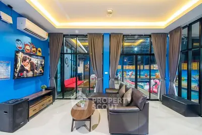 Modern living room with stylish decor and large windows overlooking a vibrant outdoor area.