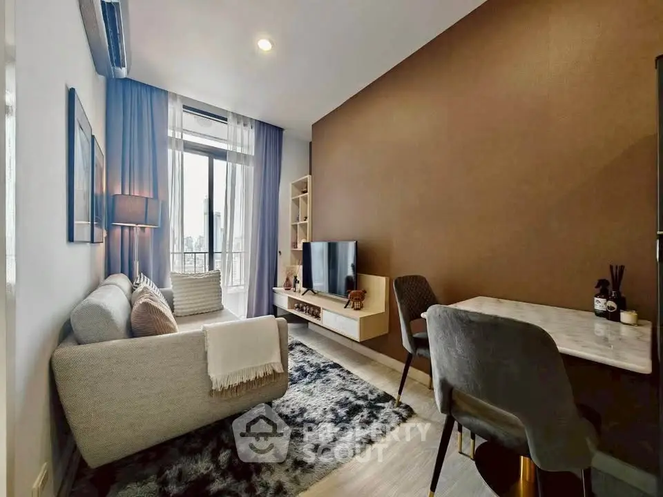 Modern living room with cozy sofa, stylish decor, and natural light from large window.