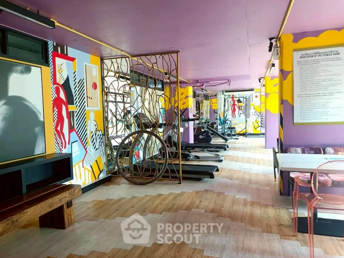 Vibrant gym with colorful murals and modern exercise equipment for an energetic workout experience.
