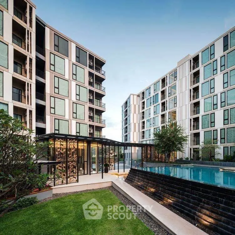 Modern apartment complex with pool and landscaped garden, showcasing contemporary architecture and luxury amenities.