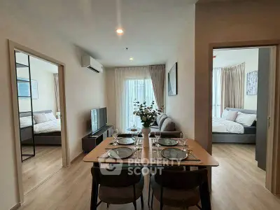 Modern apartment interior with dining area and two bedrooms, featuring stylish decor and natural light.