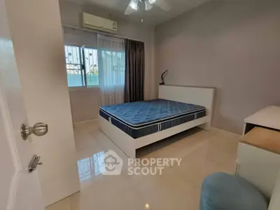 Spacious bedroom with large window and modern furnishings