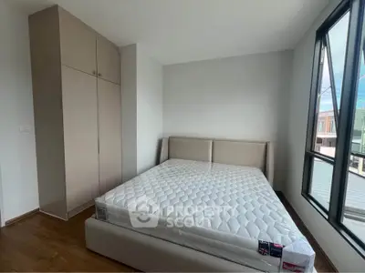 Spacious bedroom with large windows and modern wardrobe, perfect for natural light lovers.