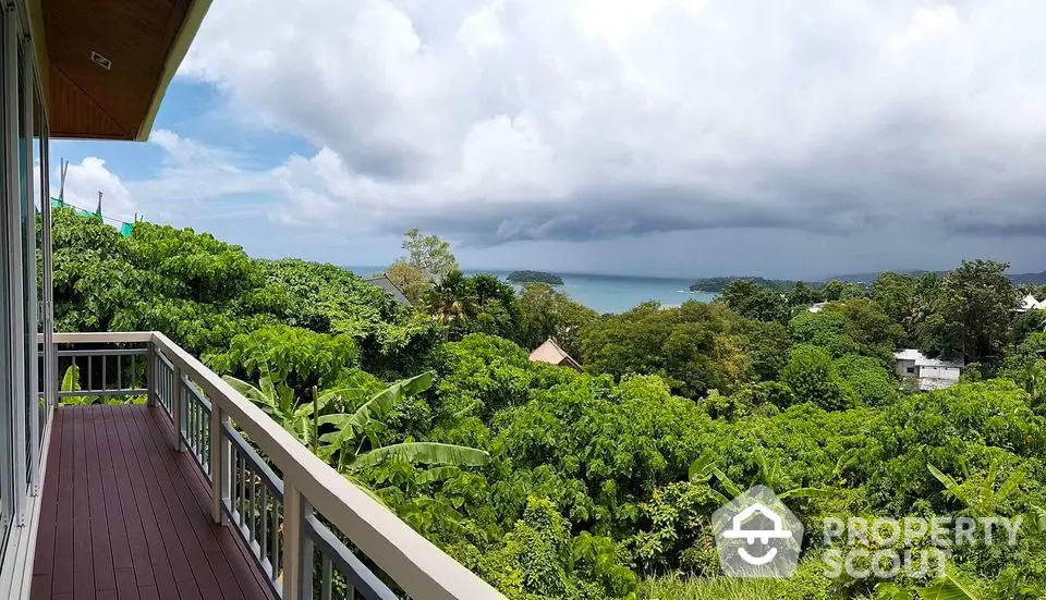 Stunning balcony view overlooking lush greenery and ocean horizon, perfect for serene living.