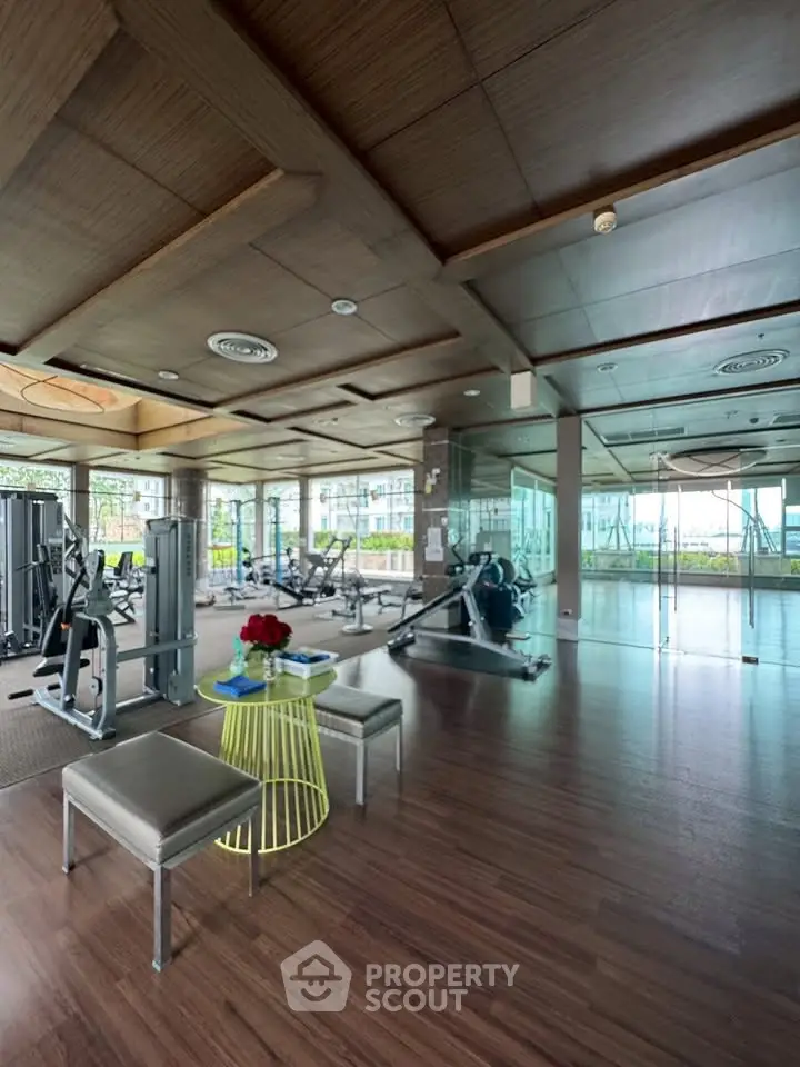 Spacious modern gym with state-of-the-art equipment and large windows offering a scenic view.