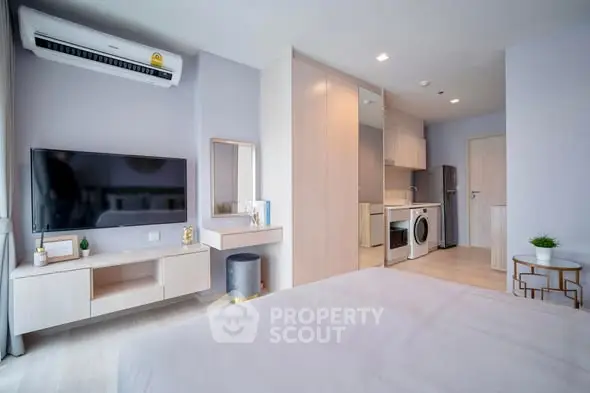 Modern studio apartment with sleek design, featuring a compact kitchen and stylish living area.