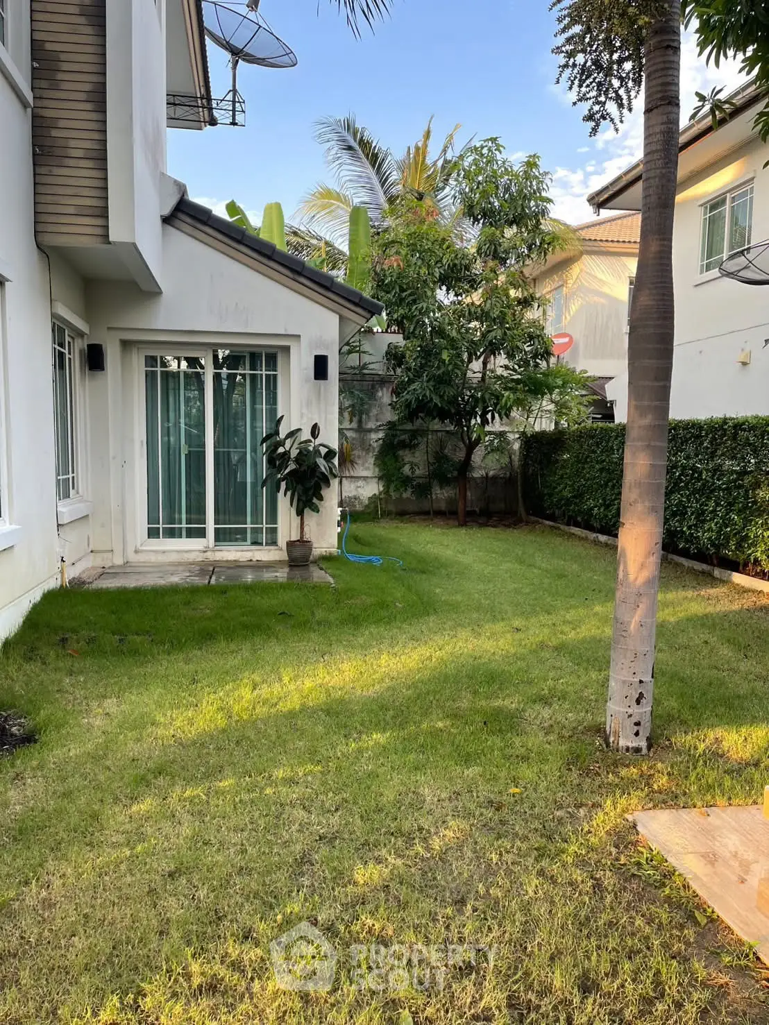 Charming suburban garden with lush greenery and modern house exterior, perfect for family living.