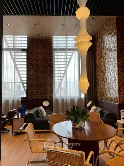 Luxurious living room with modern decor and elegant lighting, featuring stylish furniture and large windows.