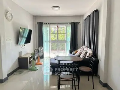 Modern living room with sleek furniture and natural light through large windows.