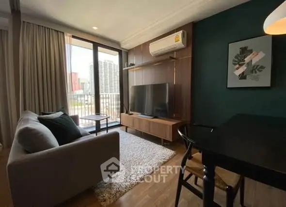 Modern living room with balcony view, featuring sleek furniture and stylish decor in a high-rise apartment.