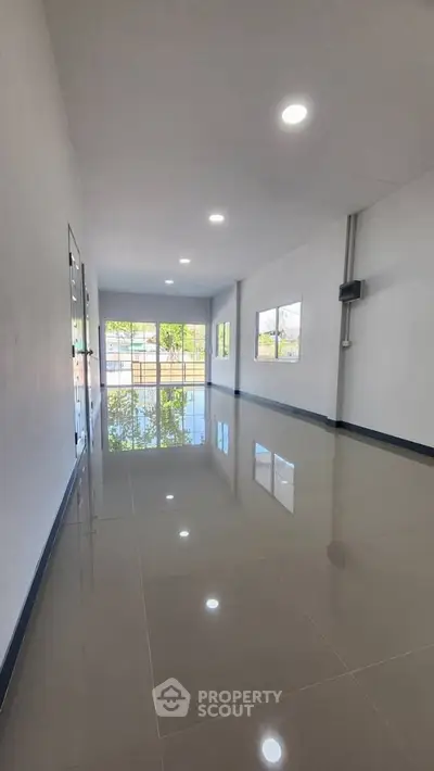 Spacious modern interior with glossy tiled floors and large windows for natural light.