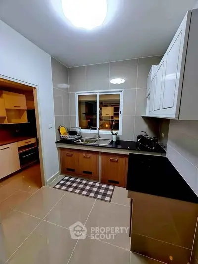 Modern kitchen with sleek cabinetry and stylish tile flooring, featuring a closed layout design.