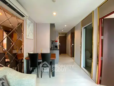 Modern apartment interior with dining area and hallway, featuring elegant decor and ample natural light.