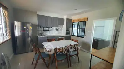 Modern kitchen with dining table and stainless steel fridge in cozy home