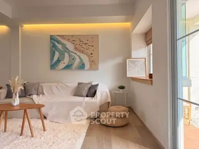 Charming living room with cozy decor and natural light, featuring a stylish beach-themed artwork.
