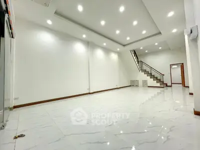 Spacious modern living room with elegant staircase and bright lighting