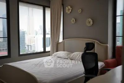 Modern bedroom with city view, featuring elegant decor and comfortable furnishings.