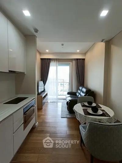 Modern living room with open kitchen and balcony view