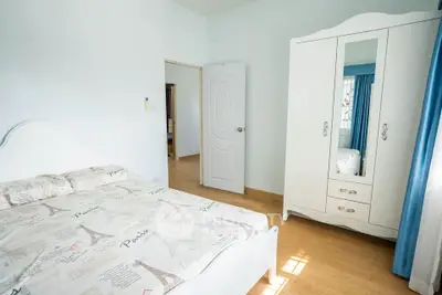 Bright bedroom with stylish wardrobe and cozy bedding in modern apartment.