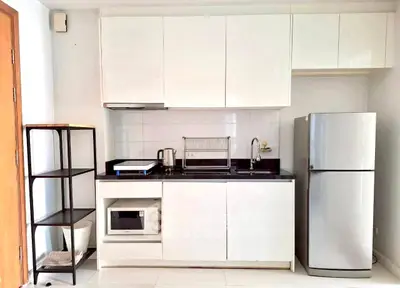 Modern compact kitchen with sleek white cabinets and stainless steel appliances