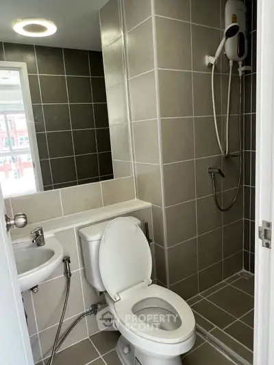 Modern bathroom with sleek shower and neutral tiles in a contemporary apartment.