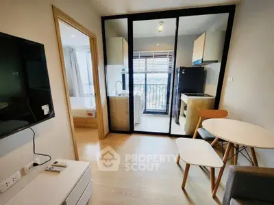 Modern apartment interior with open kitchen and cozy living area, featuring a view of the bedroom and balcony.