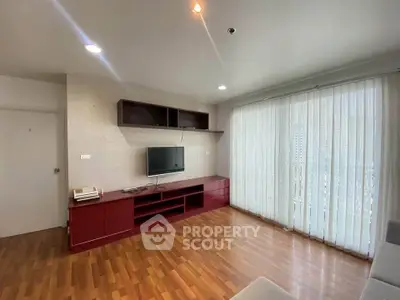 Spacious living room with wooden flooring and modern entertainment unit