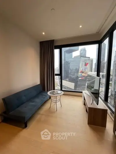 Modern living room with city view, featuring a sleek sofa and large windows in a high-rise apartment.