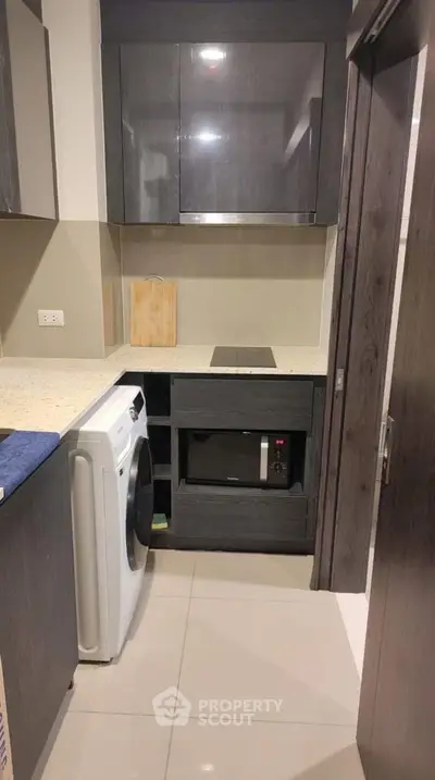 Modern compact kitchen with sleek cabinets and built-in appliances