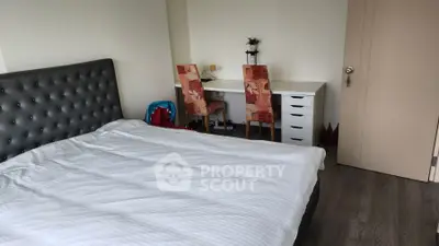 Spacious bedroom with modern decor and study area, perfect for comfortable living.